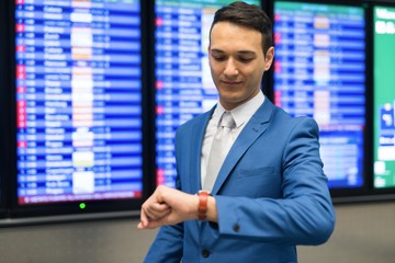 Fototapeta premium Businessman checking time while watching at a time table monitor