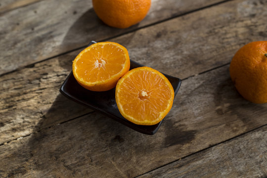 Fresh half cut oranges on wooden table