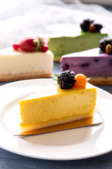 Tasty yellow cheesecake on plate three cheesecakes on background Vertical photo