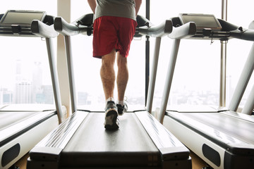 man exercising on treadmill in gym