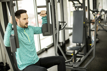 Fototapeta na wymiar Young man exercise on an exercise machine at the gym