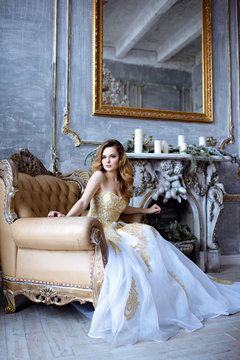Beauty bride in bridal golden gown indoors