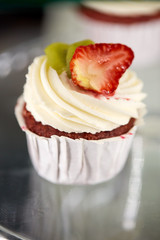 close up of cupcake with cream and strawberry