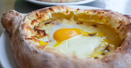 Adjarian khachapuri with eggs on the table