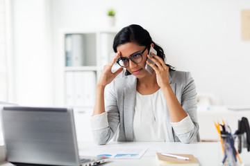 stressed businesswoman with smartphone at office