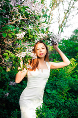  Young girl in complete tranquility and pacification in a beautiful and elegant dress on nature in the spring in the park
