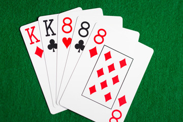 poker hand of playing cards on green casino cloth