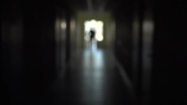 The silhouette of a man goes through the dark corridor to a bright future. The Ghost of a businessman .The path to success.