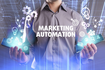 Business, Technology, Internet and network concept. Young businessman working on a virtual screen of the future and sees the inscription: Marketing automation
