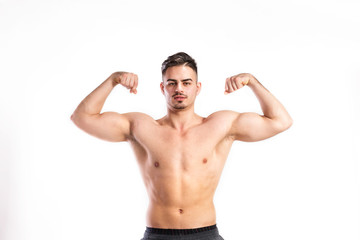 Shirtless fitness man flexing his arms. Studio shot.