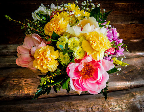 Bouquet of spring flowers snowdrops on old wooden textured board