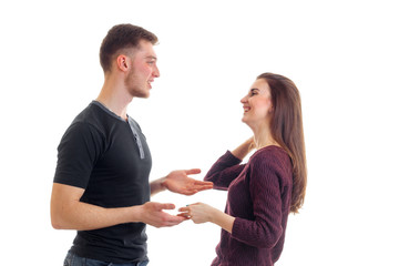 cheerful young couple stand opposite each other holding hands and laughing
