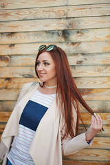 Fashion pretty redhead woman wearing in a pink jacket and stylish jeans