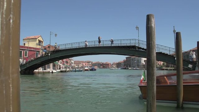 People walking over bridge in Murano