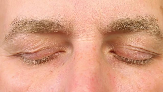 Sleeping adult man open his eyes. Extreme close-up view. Human eyes fast open up. REM rapid eye movement. See dreams sleep and wake up rapidly. Caucasian male face close open eyes. Ophthalmology.