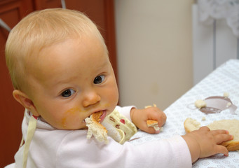 Small baby eating bread