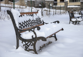snow on bench in park of winter.