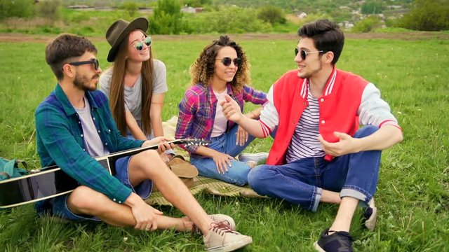 Young man tell funny stories to his friends. Other man gives five. Handsome women laughing about it. Summer lifestyle