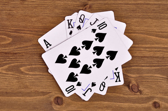 combination of royal flush of playing cards on a wooden background