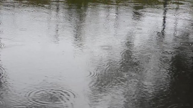Regentropfen fallen in Fluss