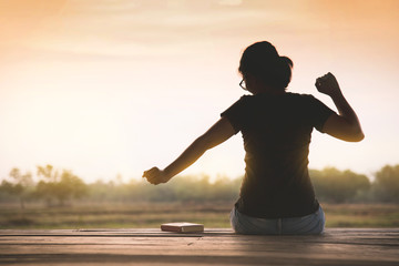 Silhouette of Asian woman waking up on countryside background.