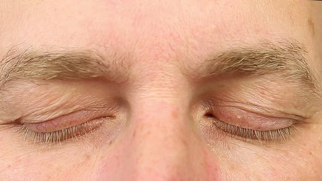 Sleeping adult man open his eyes. Extreme close-up view. Human eyes fast open up. REM rapid eye movement. See dreams sleep and wake up rapidly. Caucasian male face close open eyes. Ophthalmology.