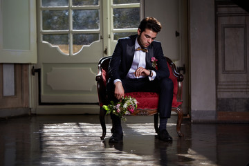 young groom waiting his bride on sofa