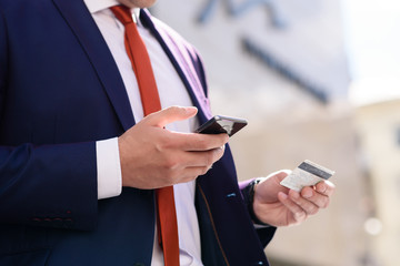 Businessman works with credit card and telephone.