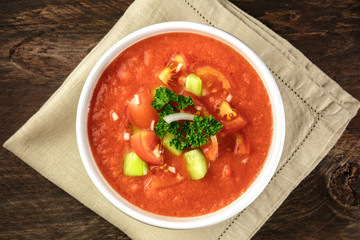 A bowl of gazpacho soup on rustic texture