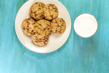 Chocolate chips cookies with glass of milk, shot from above