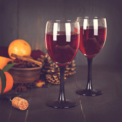 Red wine and fruit on a dark background.