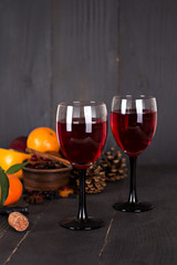 Red wine and fruit on a dark background.