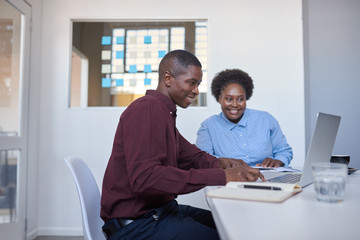 Fototapeta premium African businesspeople working on a laptop in a modern office