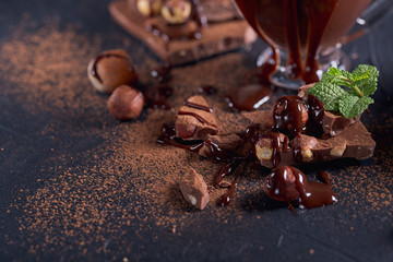 Homemade hazelnut spread or hot chocolate in glass bowl with nuts and chocolate bar.