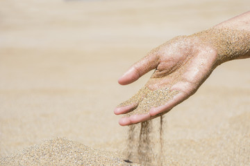 The Sand sliding by the hand on the beach