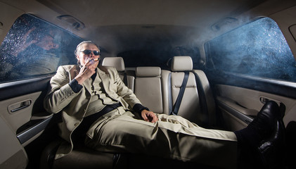 A rich man in a white suit and a cigar in the car, a limousine