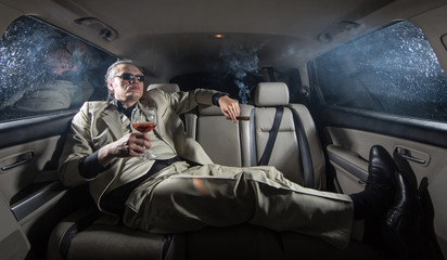 A rich man in a white suit and a cigar in the car, a limousine