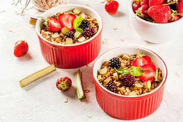 Healthy breakfast. Oatmeal granola crumble with rhubarb, fresh strawberries and blackberries, seeds...