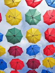 Colorful umbrellas on blue sky background