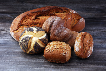 Different kinds of bread and bread rolls on board from above. Kitchen or bakery poster design.