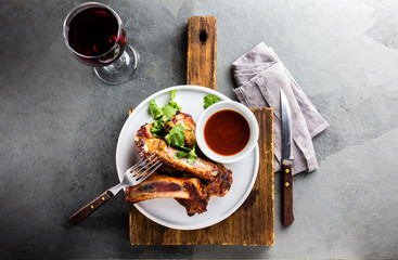 Pork ribs on white plate with chili sauce