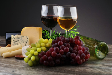 Cheese platter with different cheese and grapes and red wine