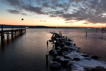 Fototapeta premium Cloudy sky and winter sea at the sundown
