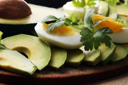 Sandwich with avocado and poached egg - healthy breakfast concept