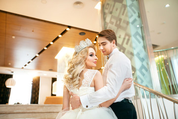 Beautiful young newlyweds in wedding dresses in a modern interior