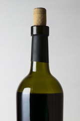 Red wine bottle and corkscrew on white wooden table background with copy space