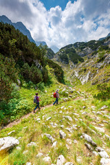 Fototapeta na wymiar Two people are hiking. Good sunny day in Montenegro. Balkan mountains.