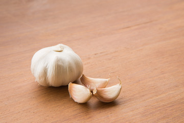 Organic garlic whole and cloves on the wooden background