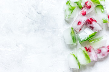 ice cubes with red berries and mint top view gray stone background mockup