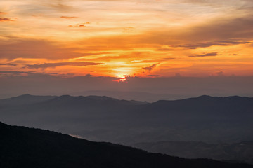 Beautiful landscape nature on mountain with sun cloud fog and bright colors of sky and sunlight during sunset in winter at view point Phu Chi Fa Forest Park in Chiang Rai Province, Thailand